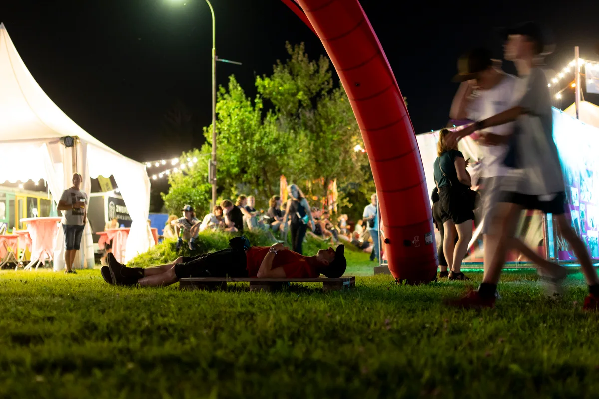 Mit genug Schlaf geht es am Samstag und Sonntag mit zahlreichen weiteren Bands weiter. Auf einer Holzpalette liegt ein Mann, der in den Himmel starrt.